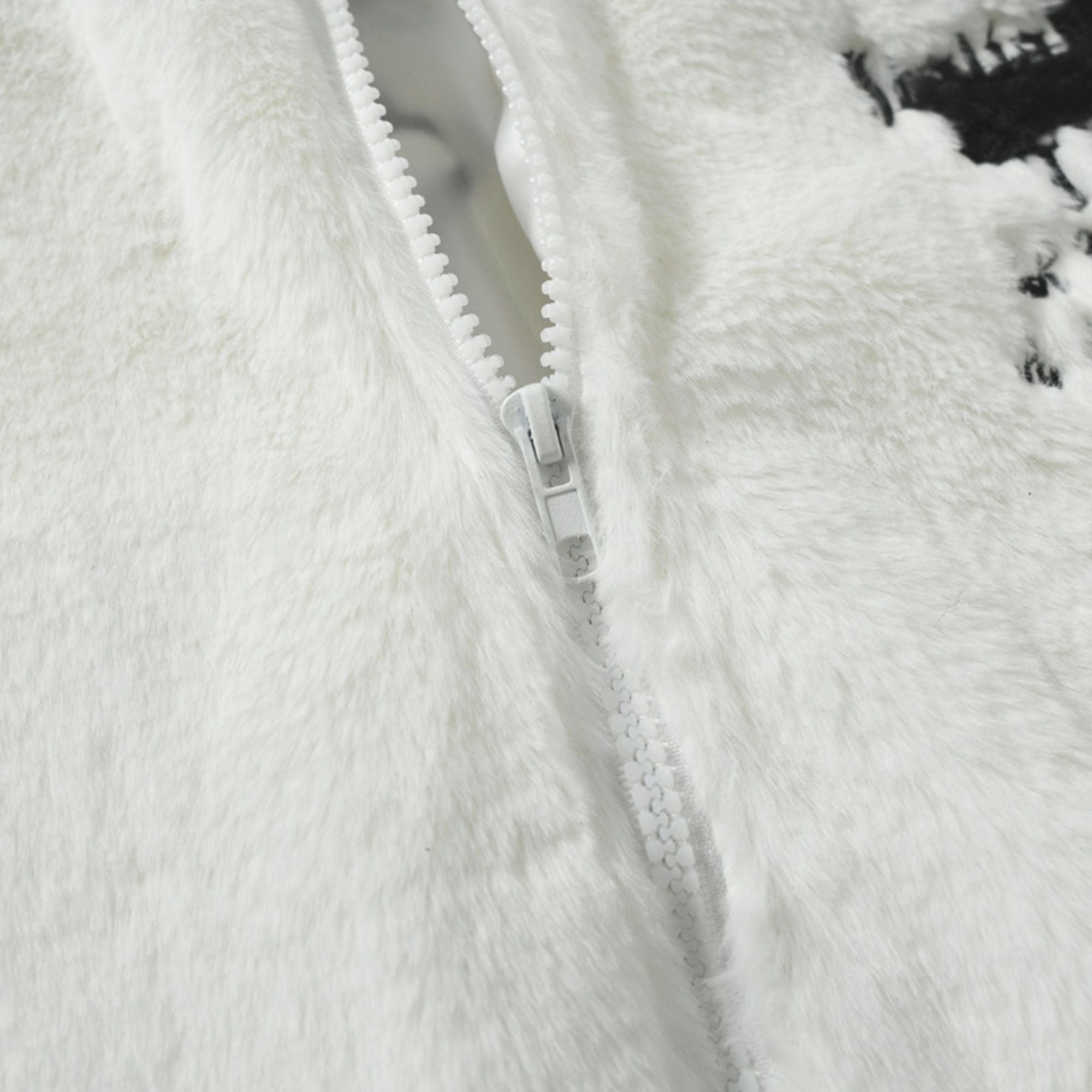 Close-up of a white fuzzy jacket with a zipper