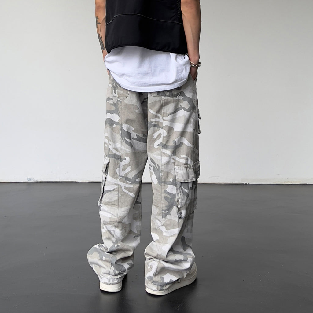 Person wearing camouflage cargo pants with a plain background
