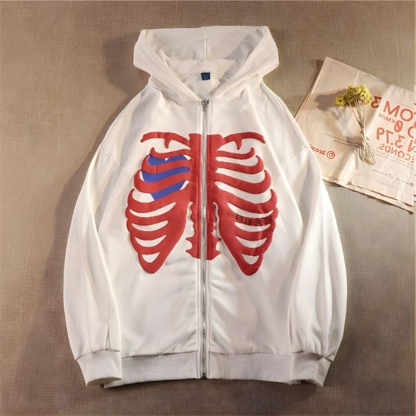 White hoodie with red ribcage design on a beige surface