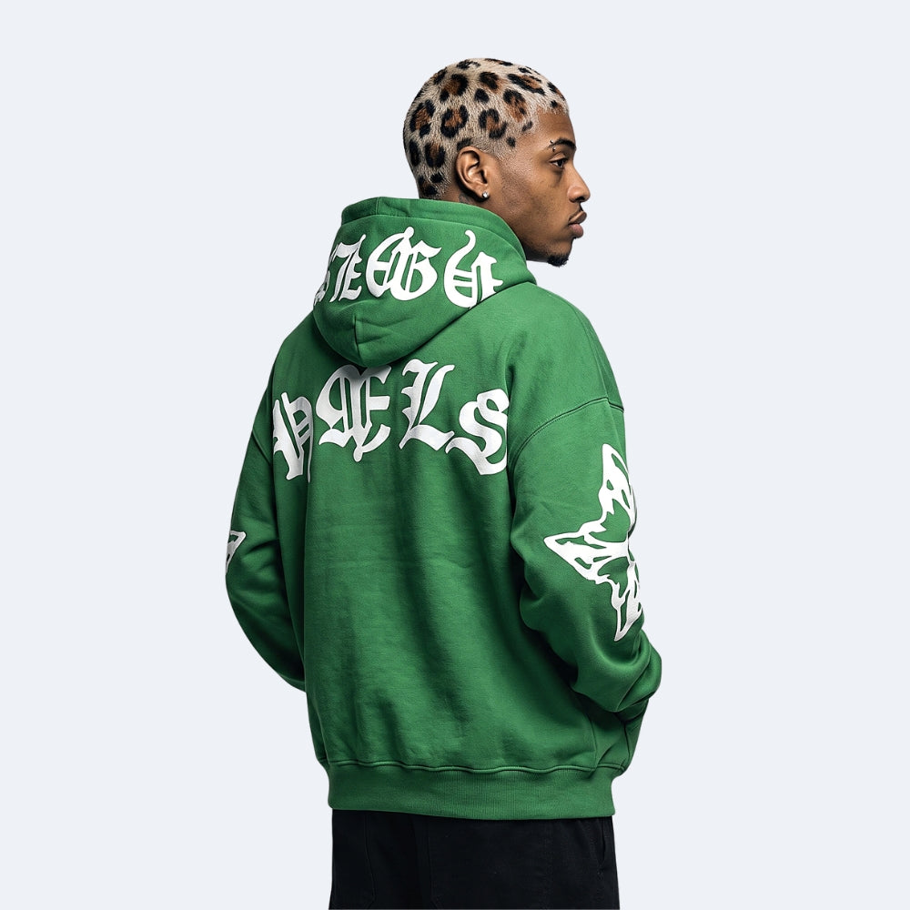 Green. A man shown from the back wearing a green pullover hoodie with large white gothic-style lettering and graphics across the back and sleeve.