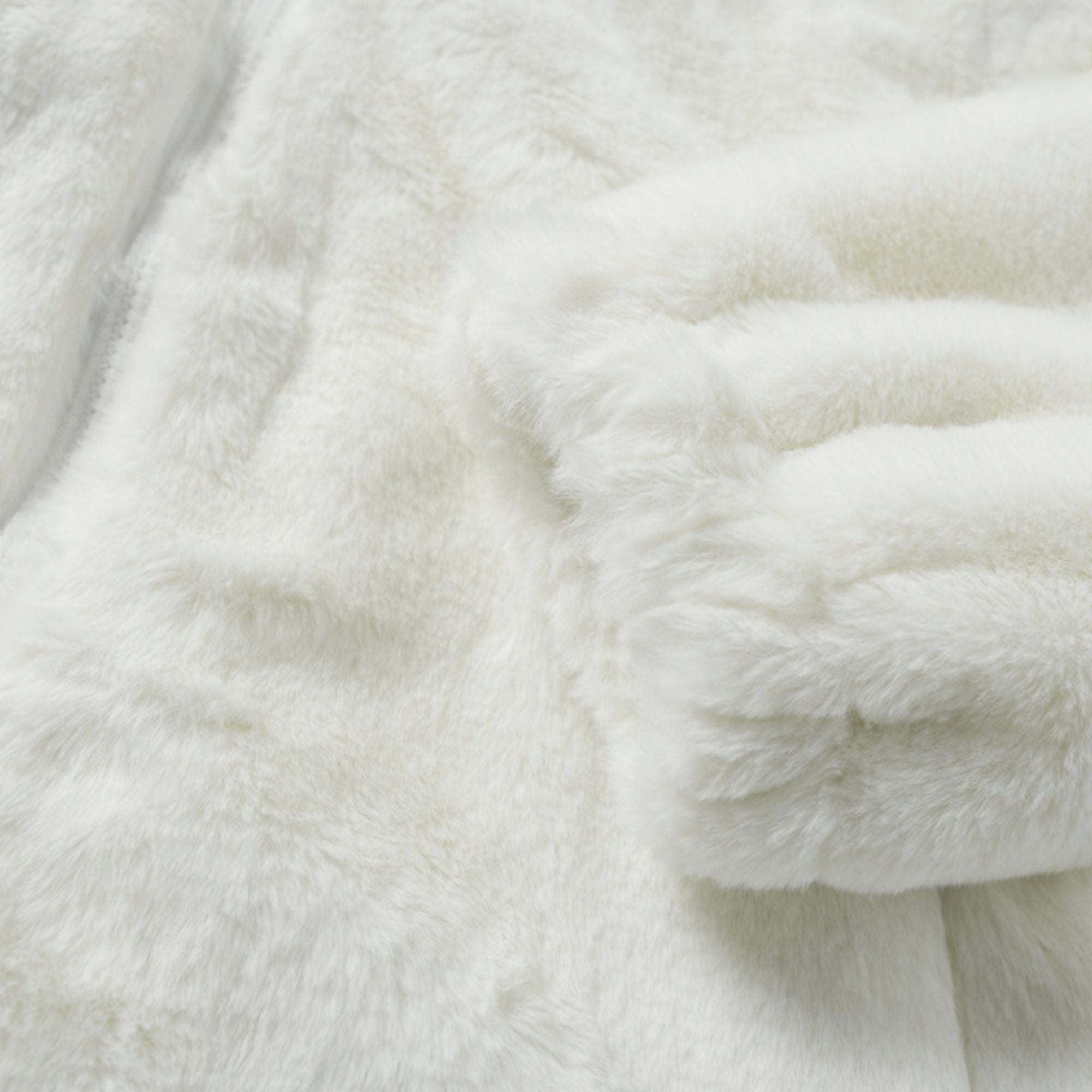 Close-up of a white fluffy blanket with a textured surface.