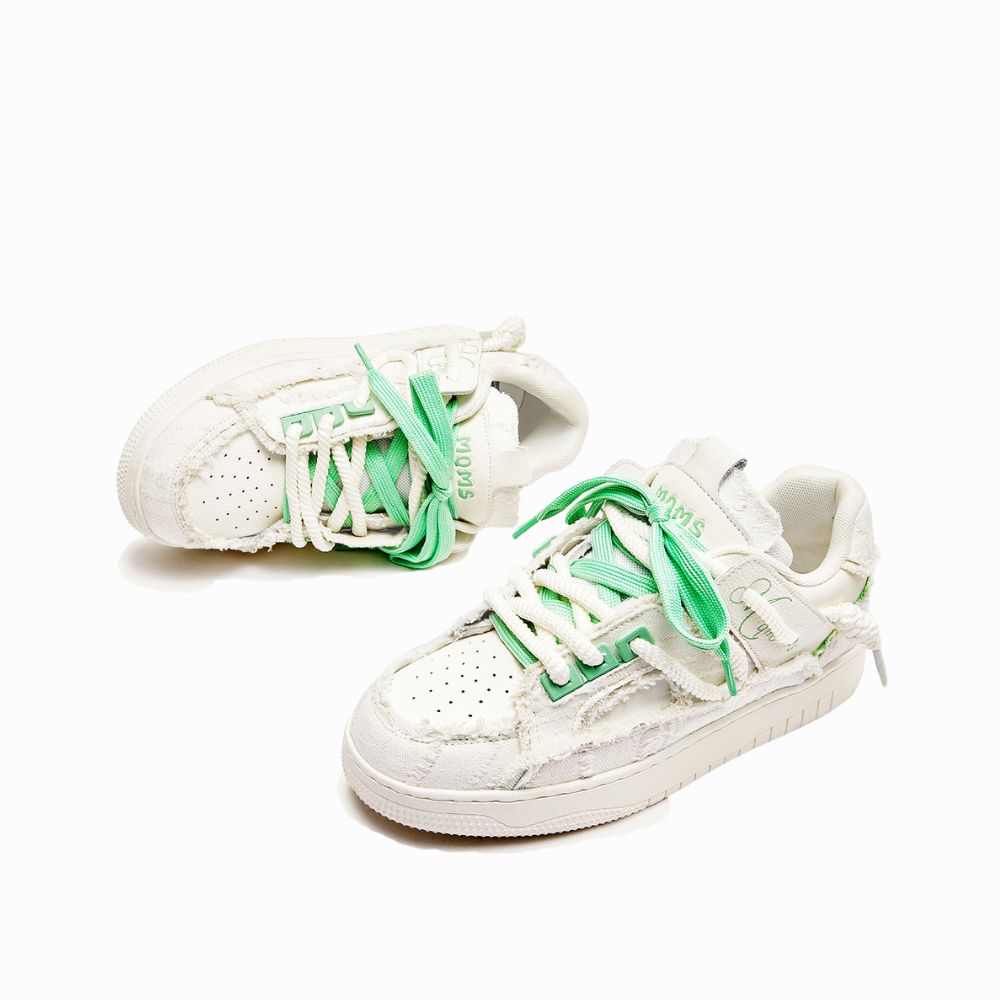 White sneakers with green laces on a white background