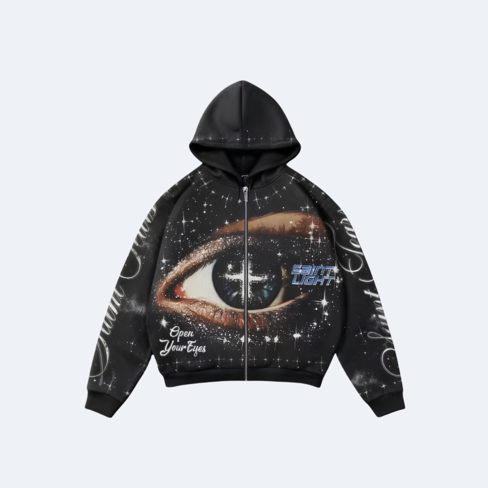 Black. A black zip-up hoodie with a large eye graphic on the front, surrounded by white stars and text, shown flat.