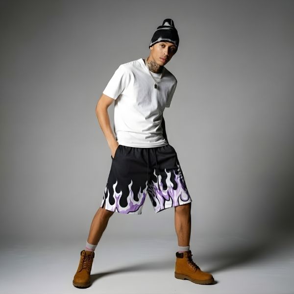 Person wearing a white t-shirt, black shorts with flame design, and brown boots on a gray background