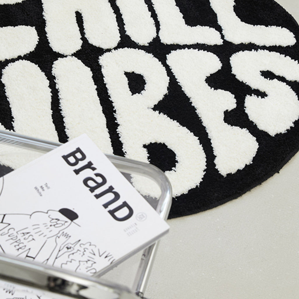 Black and white rug with 'Hill Tribes' branding, featuring a book on top.