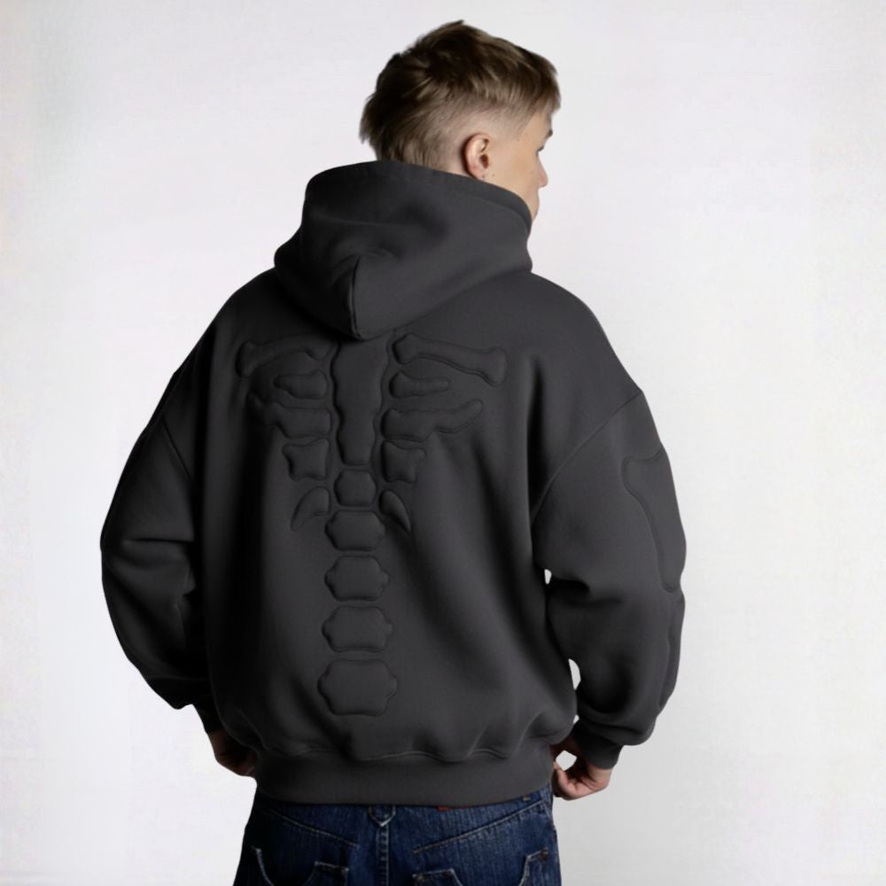 Person wearing a black hoodie with geometric patterns on the back against a white background