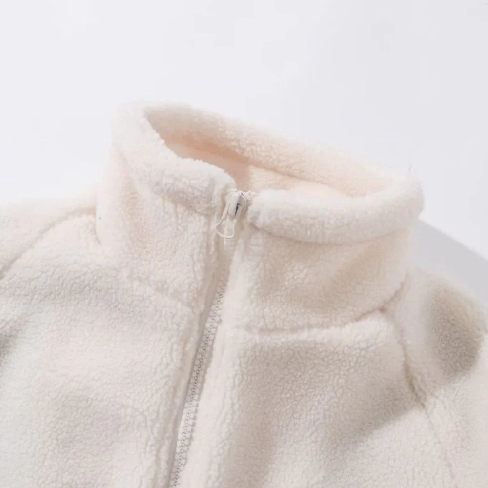Close-up of a beige fleece jacket with a zipper on a light gray background