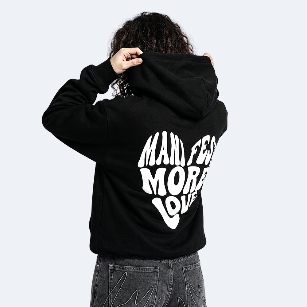 Black. A person shown from the back wearing a black hoodie with a large white graphic text print, paired with dark gray jeans.