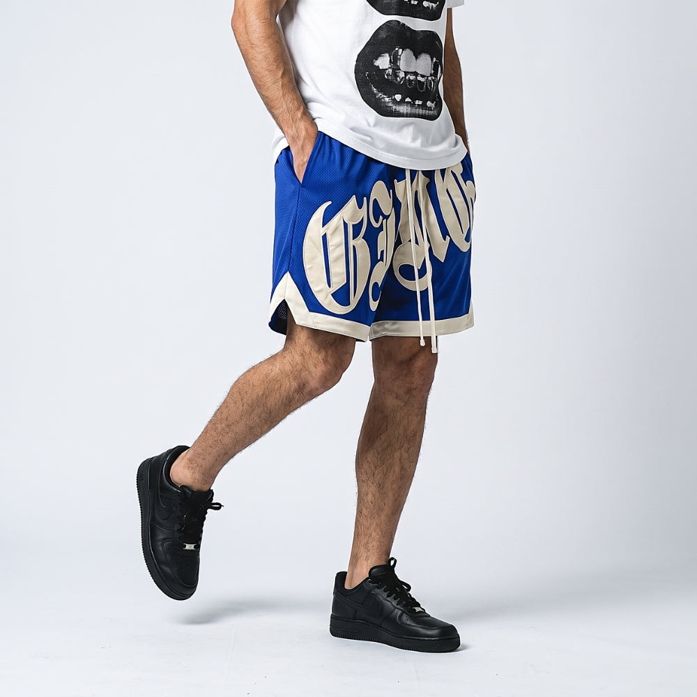 Blue. A model wearing blue and white basketball shorts with a white graphic t-shirt and black sneakers.