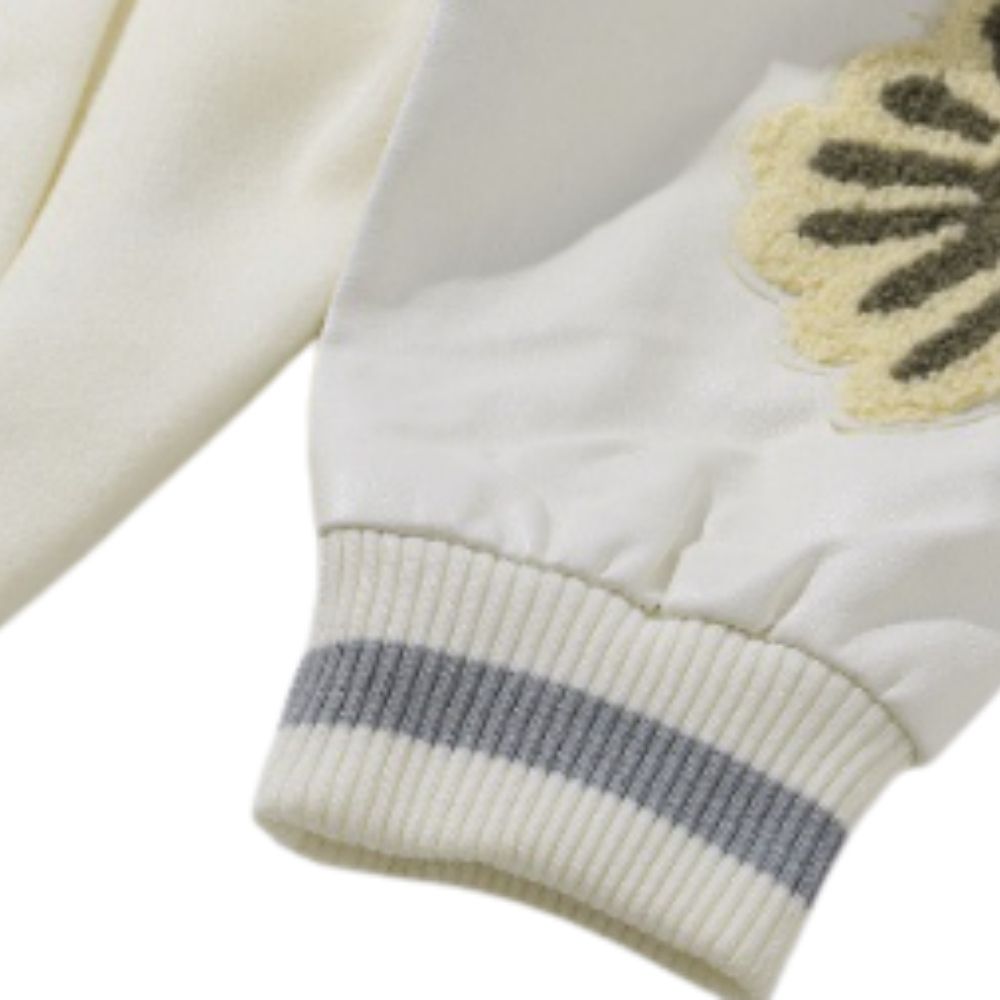 Close-up of a cream-colored garment with a logo on a white background