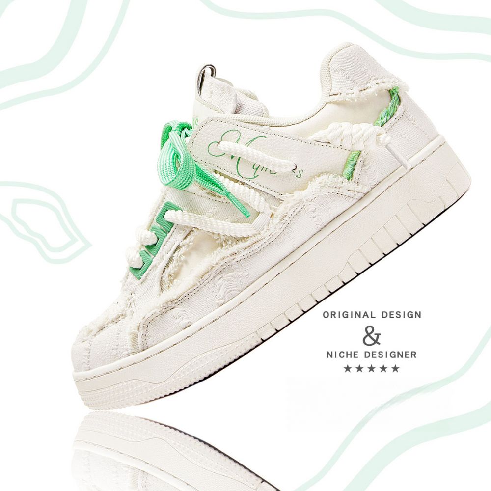 White sneaker with green accents on a light gray background