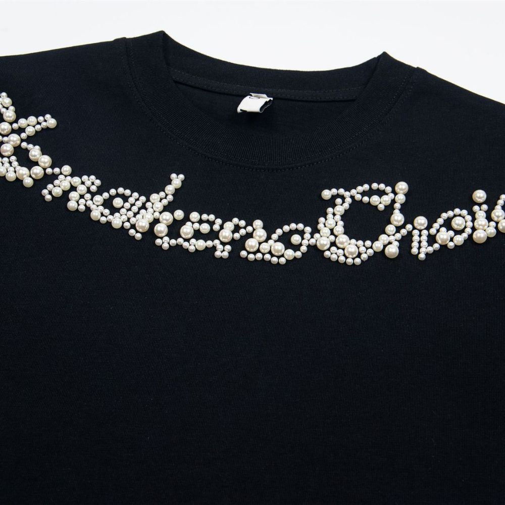 Black garment embroidered with pearls on a white background