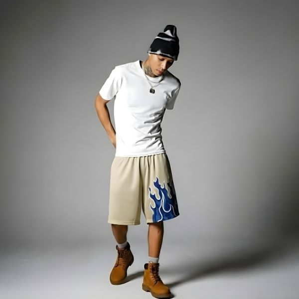 Person wearing a white t-shirt, beige shorts with a blue design, and brown boots on a gray background