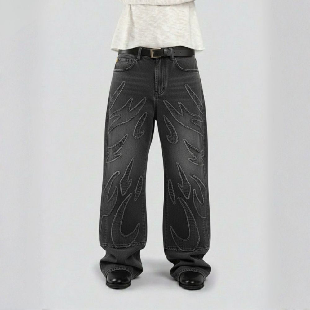 Black jeans with unique designs on a plain background