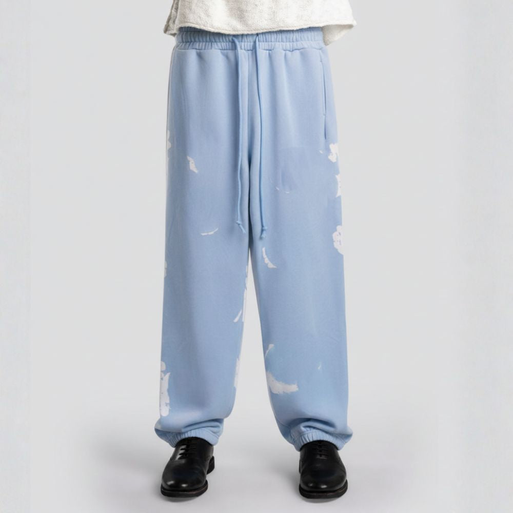 Light blue sweatpants with cloud pattern worn by a person on a white background