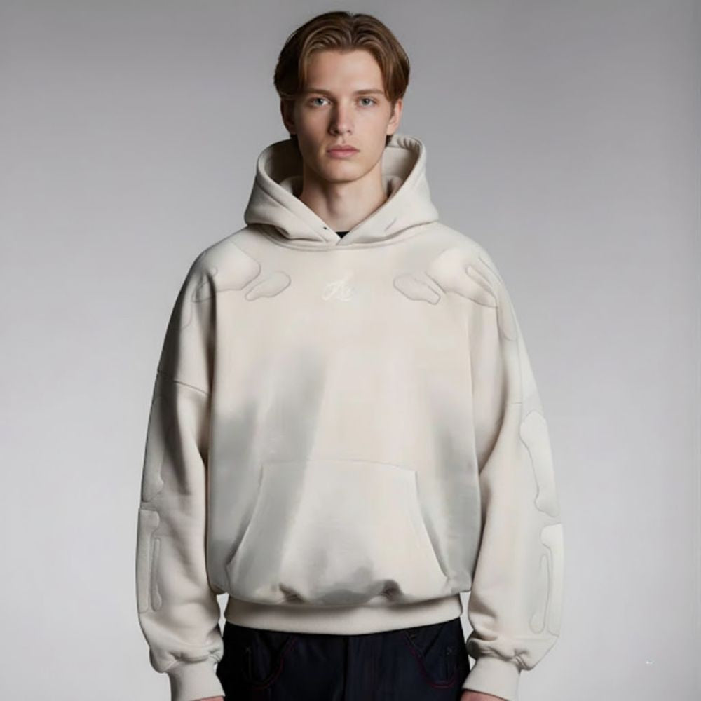 Person wearing a beige hoodie on a plain background