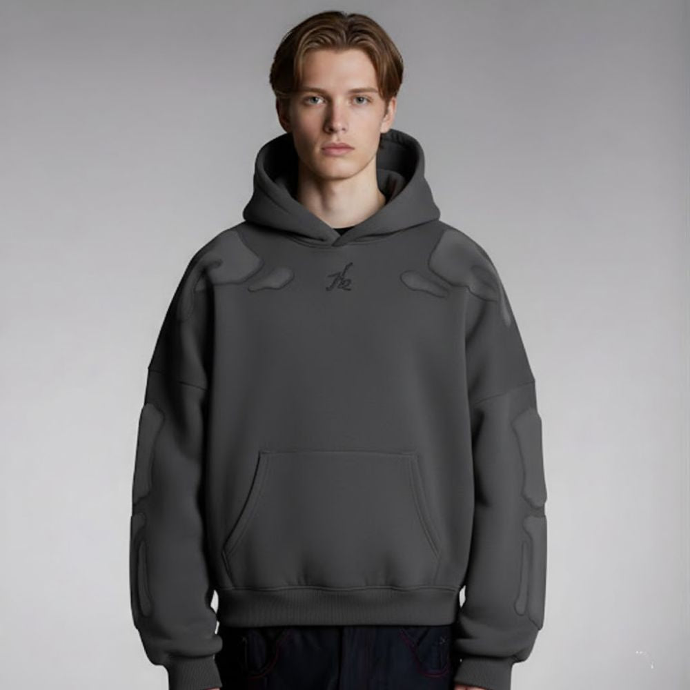 Person wearing a gray hoodie with a brand logo on a gray background