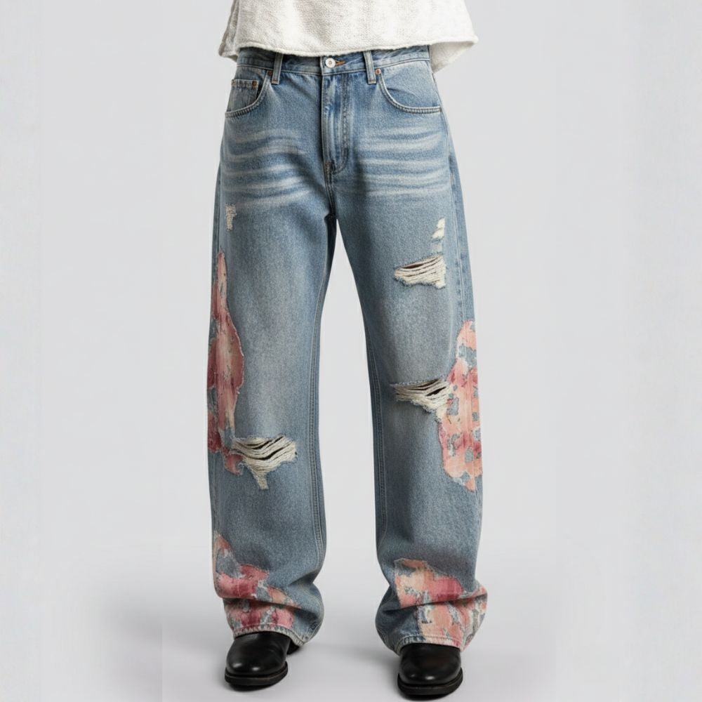 Distressed blue jeans with floral patterns on a white background