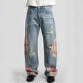 Distressed blue jeans with floral patterns on a white background