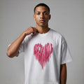 Person wearing a white t-shirt with a pink heart design on a gray background