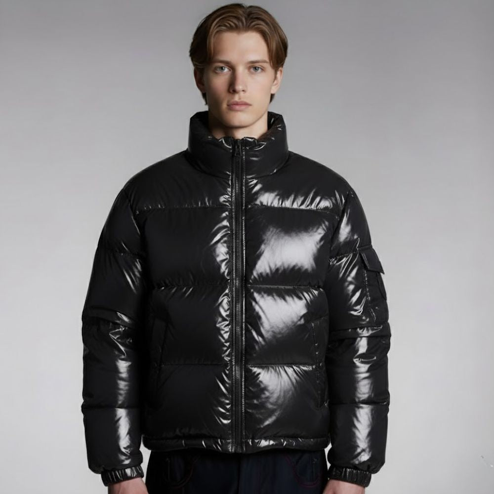 Man wearing a black puffer jacket against a gray background