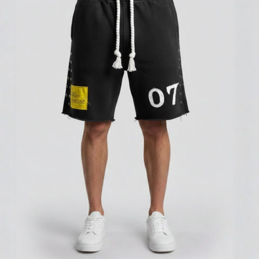 Black shorts with a yellow patch and white text on a white background