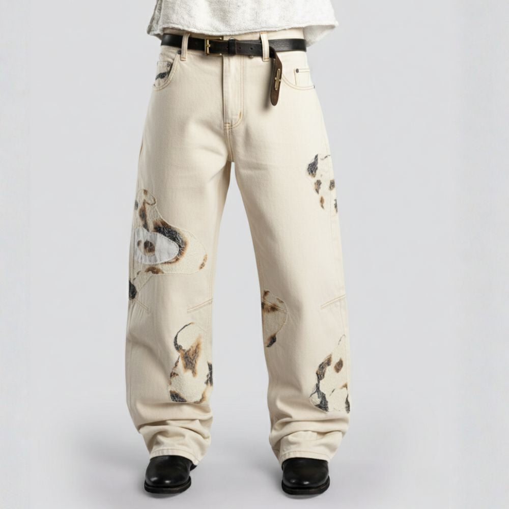 Beige pants with abstract patterns worn by a person on a light gray background