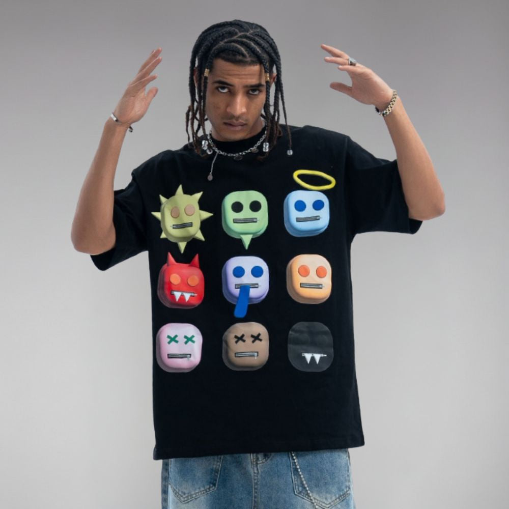 Person wearing a black t-shirt with colorful emoji designs on a plain background