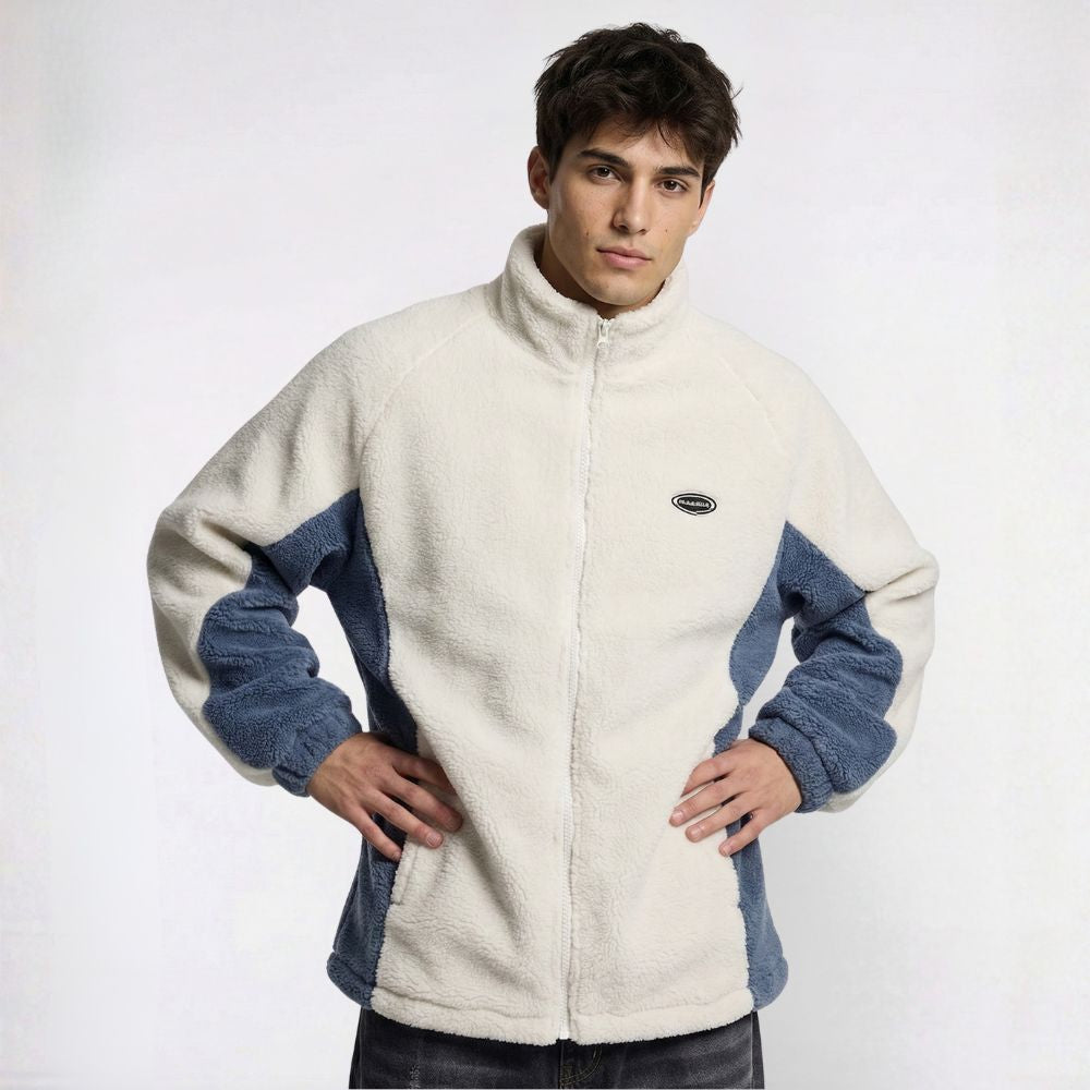 Man wearing a cream and blue fleece jacket on a white background