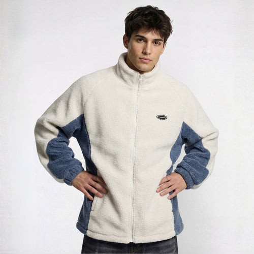 Man wearing a cream and blue fleece jacket on a white background