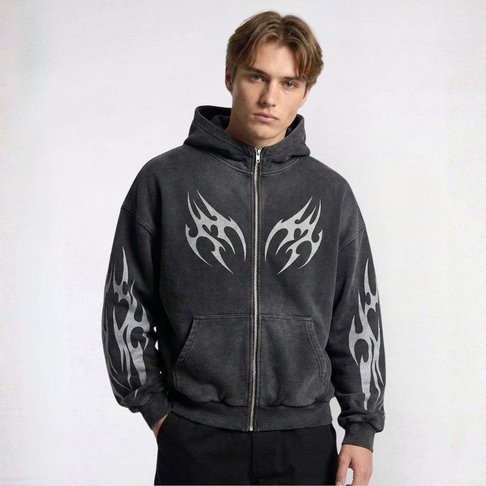 Person wearing a black hoodie with tribal designs on a white background