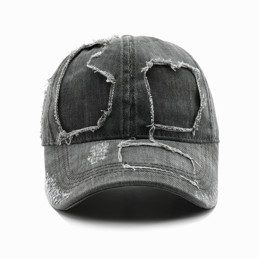 Distressed denim cap with worn-out design on a white background