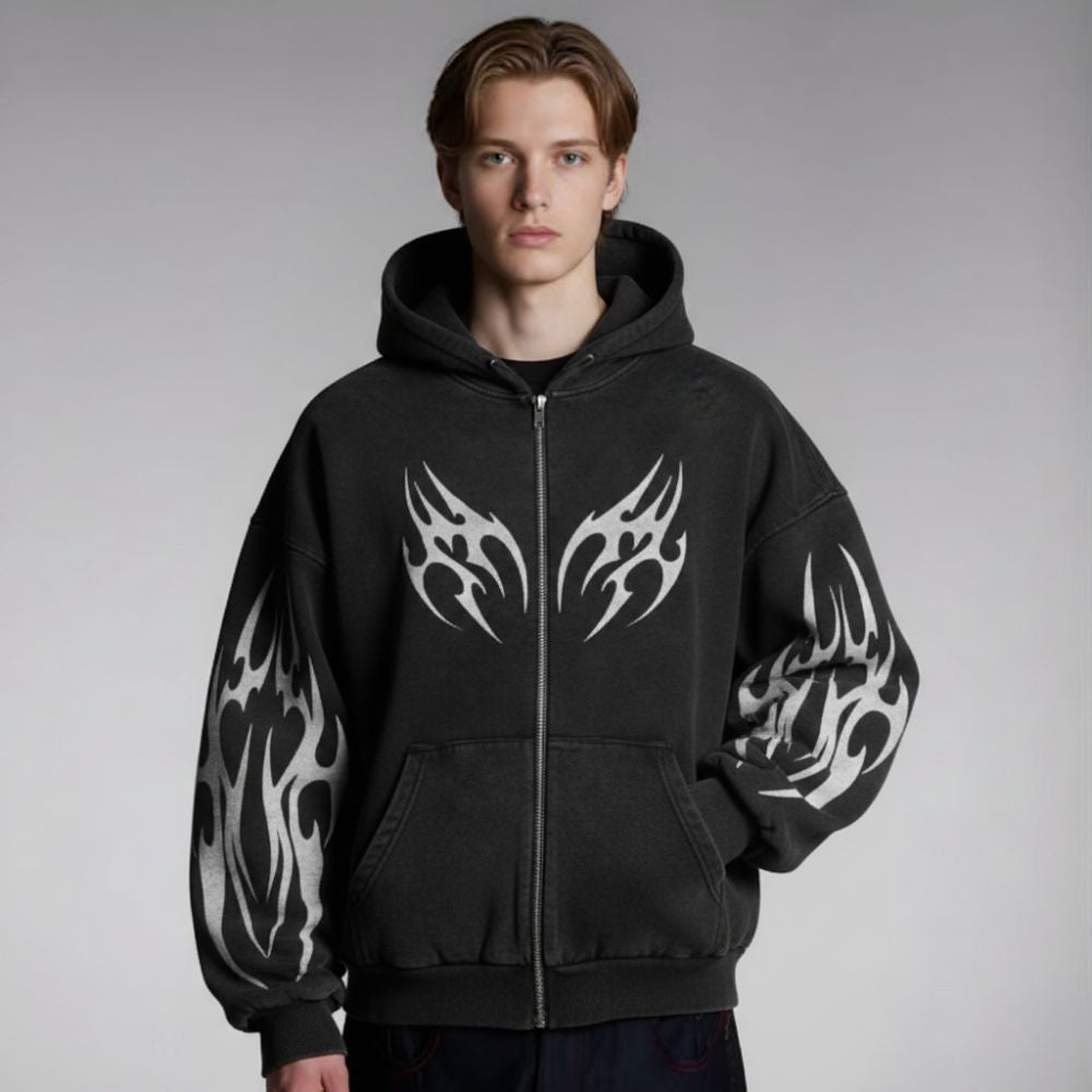 Person wearing a black hoodie with white tribal designs on a gray background