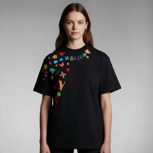 Person wearing a black t-shirt with colorful designs on a gray background